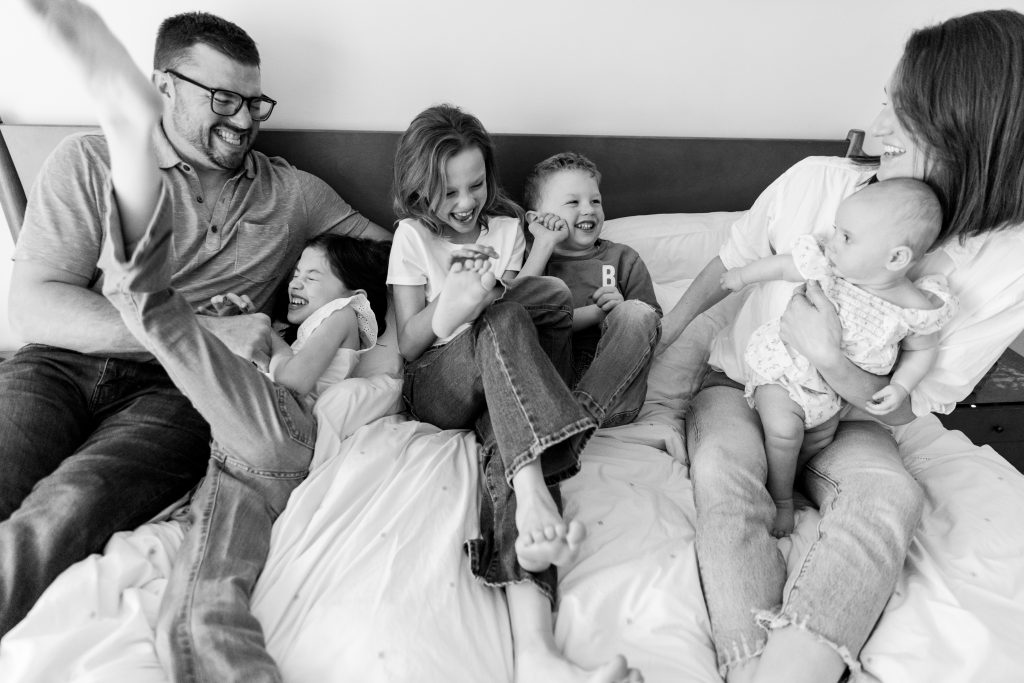 family laughing on bed
